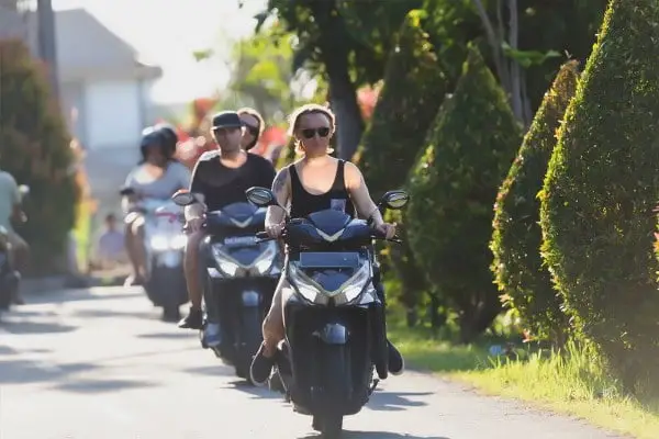 Woman riding Vario scooter on Bali street, illustrating How to rent motorbike or scooter in Bali