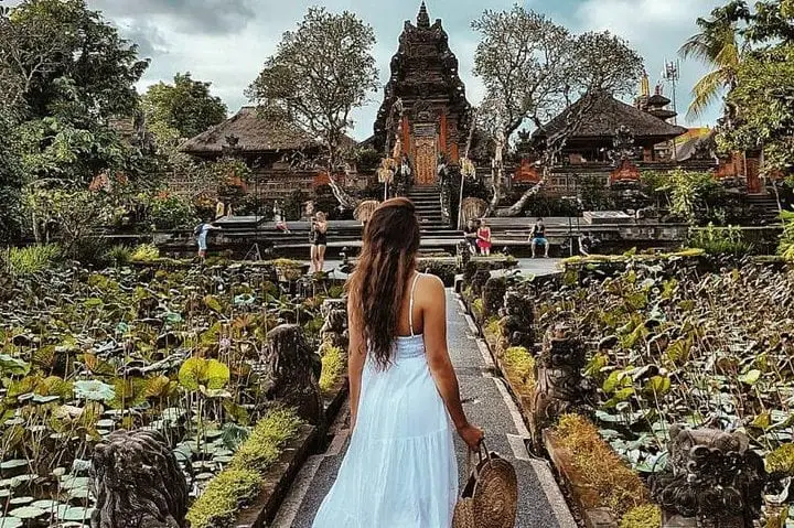 Woman facing temple by a lake, enjoying Spiritual and Cultural Experience in Ubud