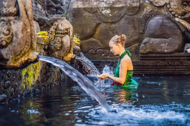 Woman experiencing spiritual excitements at a traditional Balinese holy spring temple