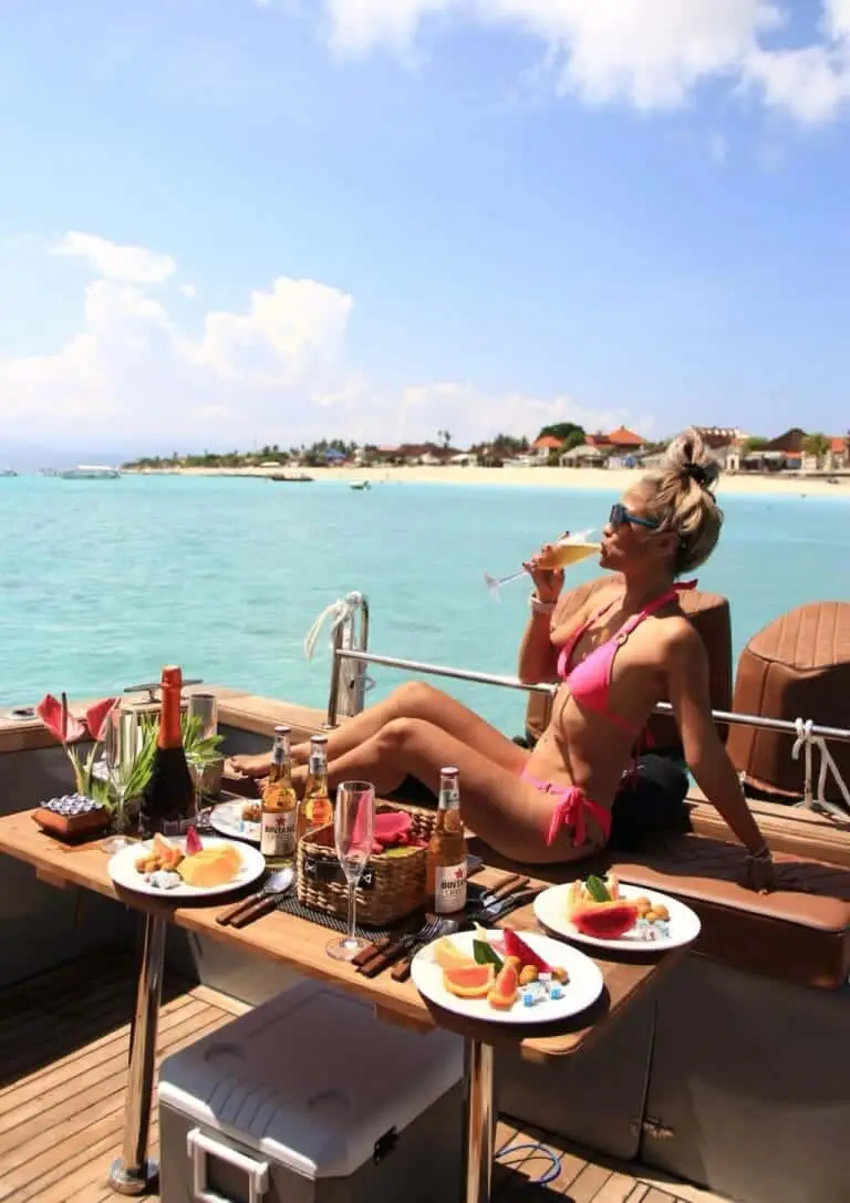 Guest relaxing on the deck during the Sunset Escape Private Cruise in Nusa Dua, enjoying snacks and ocean views.