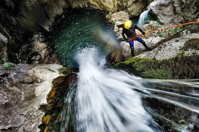 Tourist enjoying canyoning waterfall adventure in Bali with professional guide and stunning jungle surroundings