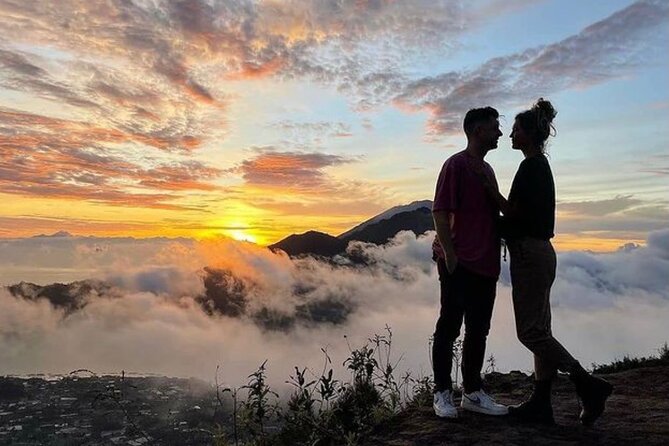 Bali couple tour enjoying sunrise together at Mount Batur.