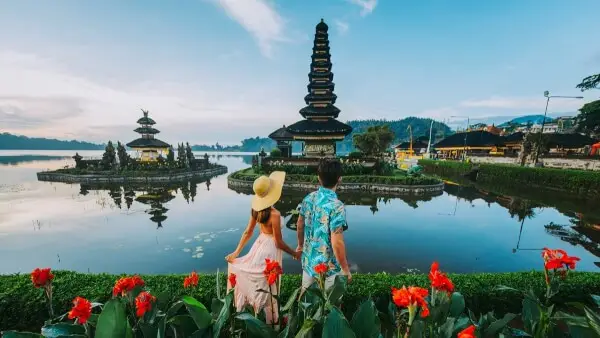 Couple exploring Ulun Danu Beratan Temple by the lake, featured in a Bali tour and travel experience.