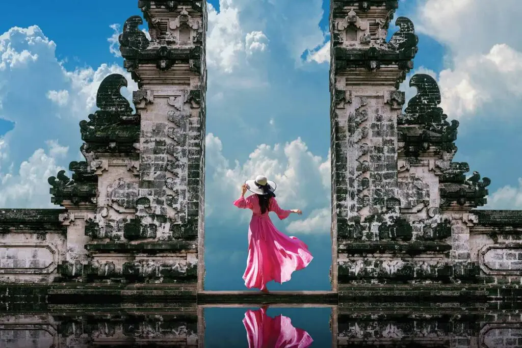 Tourist posing between Bali’s famous Handara Gate, capturing a moment from a Bali tour and travel itinerary.