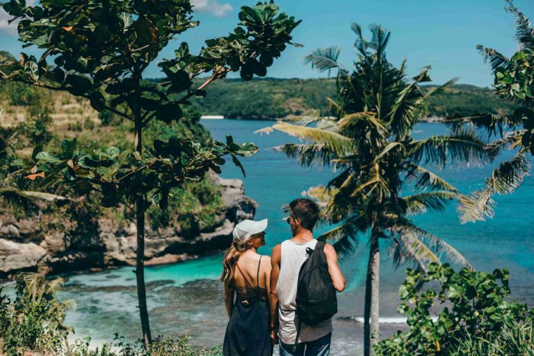 Romantic Bali tours – honeymoon couple admiring the stunning ocean view from a scenic Bali viewpoint.