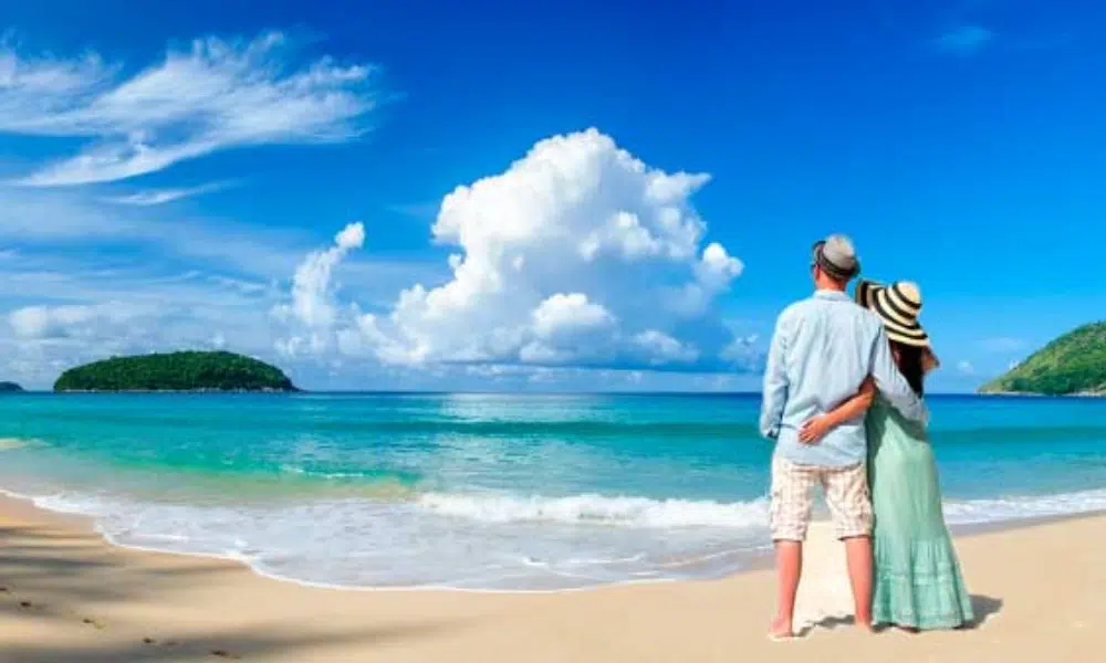 Bali couple tour walking hand in hand on a beautiful tropical beach.