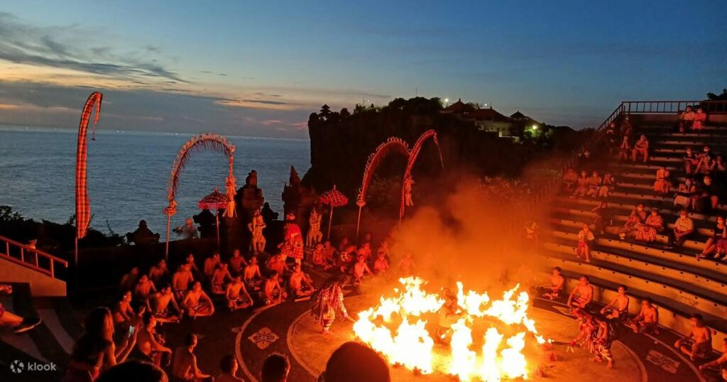 Tourists watching Kecak Fire Dance at Uluwatu Temple during sunset – cultural experiences in Bali