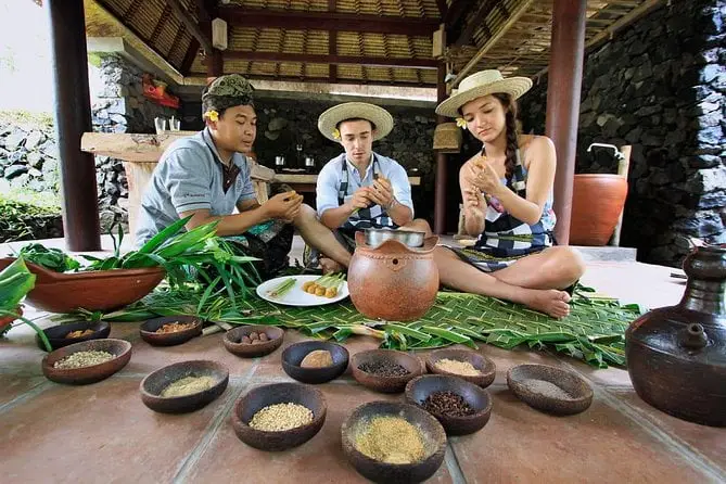 Tourists enjoying a traditional cooking class as part of a Bali tour and travel cultural experience.