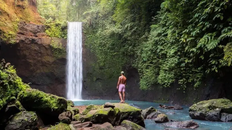 Traveler enjoying waterfall adventure guided by expert Bali tour guide on custom tour in Bali