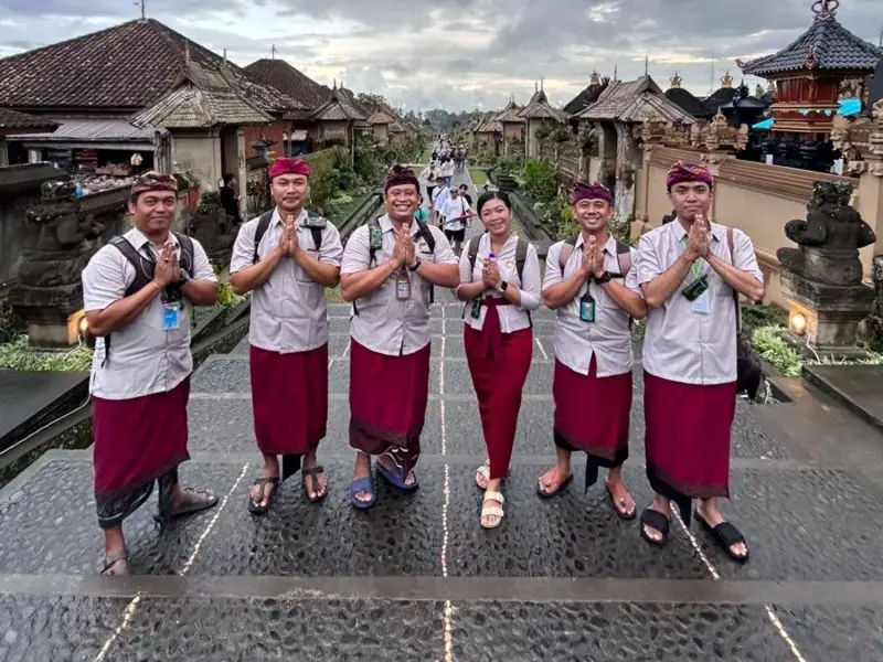 Group of Bali tour guides welcoming travelers at traditional Balinese temple
