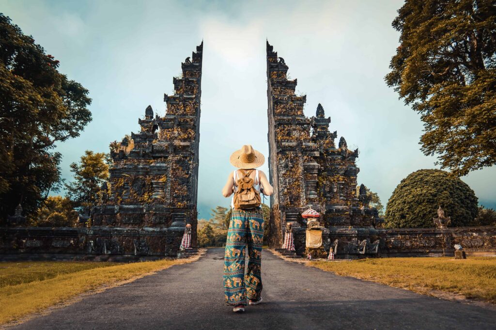 Visitor exploring the iconic Handara Gate surrounded by mountains on a Flexible Bali Tour.