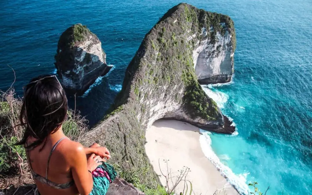 Couple admiring the cliffs and turquoise sea at Kelingking Beach on a Flexible Bali Tour.