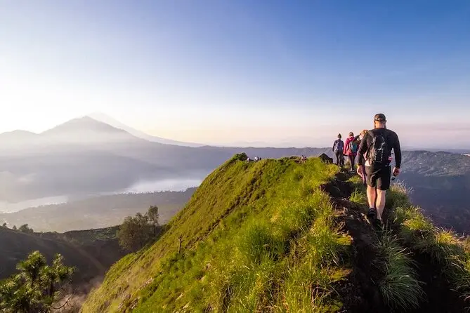 Hikers enjoying Mount Batur sunrise trekking with Bali Adventure Tour in scenic nature.