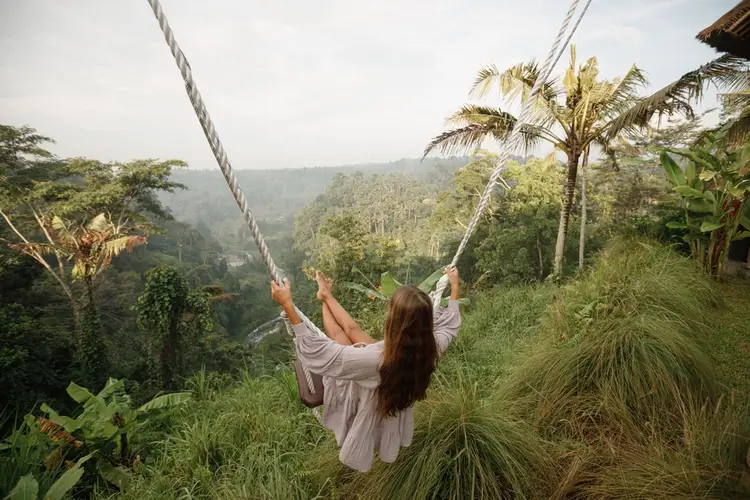 Woman on the famous jungle swing in Tegallalang during her Flexible Bali Tour.